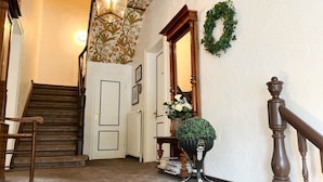 A staircase with a wooden handrail, a wall-mounted light fixture, and a decorative wreath. - House Friesland - Apartment 1 - An urban villa with spacious and tasteful (Sylt)
