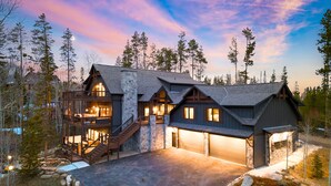 A large, multi-story log cabin with a stone foundation, multiple decks, and a garage. - Hot Tub, Firepit & Views, Sleeps 19 | Winterhaven Estate by AvantStay (Winter Park)