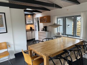 A modern kitchen with a microwave, cabinets, and a dining area with a table and chairs.
