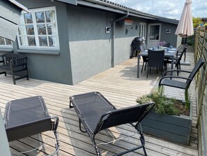 A patio with outdoor furniture, a grill, and a table with chairs. - Lovely cottage near beautiful bathing beach (Otterup)