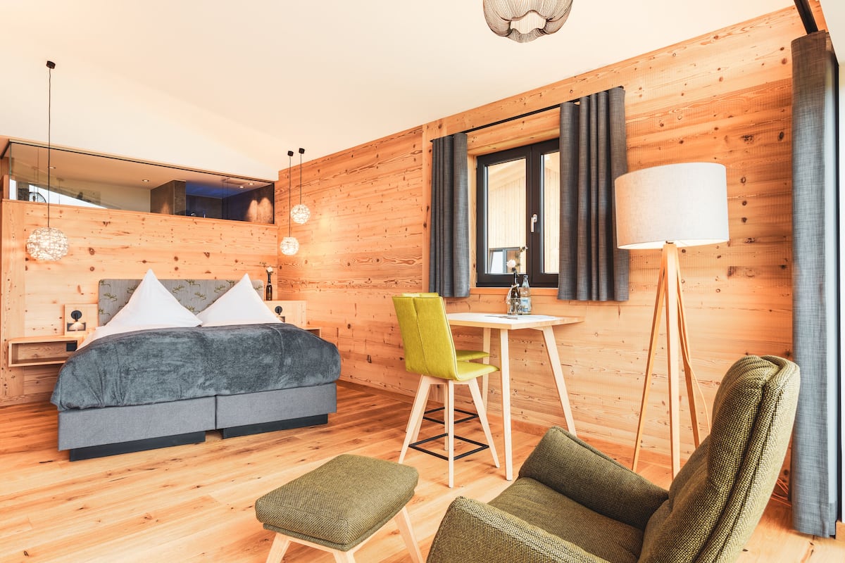 Een moderne kamer met een houten inrichting, een bed, een bureau en een stoel.