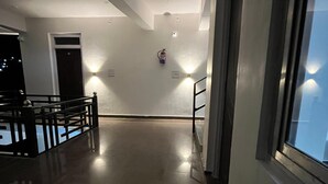 Un couloir doté d’un plancher ciré, d’un extincteur fixé au mur et d’une porte au fond.