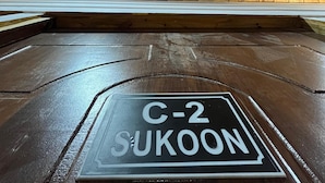 Un intérieur en bois avec une enseigne indiquant « C-2 SUKOON ».