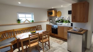 Una cocina compacta con armarios de madera, horno integrado y refrigerador.