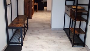A hallway with a wooden bench, a metal bench, and a bookshelf. - Apartment 'Am Dächsberg' with Private Terrace and Wi-Fi (Plauen)
