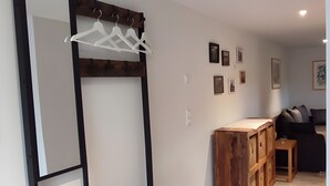 A modern interior with a bench, a mirror, and a wooden cabinet. - Apartment 'Am Dächsberg' with Private Terrace and Wi-Fi (Plauen)