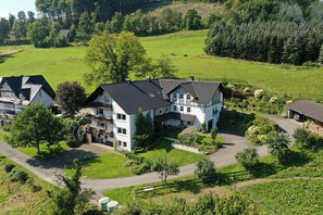 Ein großes, zweistöckiges Haus mit einem geräumigen Vorgarten, einer Auffahrt und einem eingezäunten Garten.