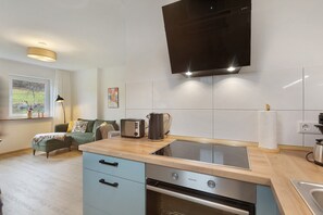 Eine moderne Küche mit Einbauherd, Backofen und einem flachbildfernseher an der Wand.
