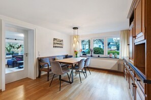 Una cucina moderna con un tavolo da pranzo, sedie e vista all'esterno.