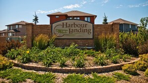 Schild für Harbour Landing mit einer Ziegelwand und angelegten Gartenanlage im Vordergrund.