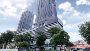 Un immeuble moderne de grande hauteur, doté d’une façade en verre et d’un toit plat.
