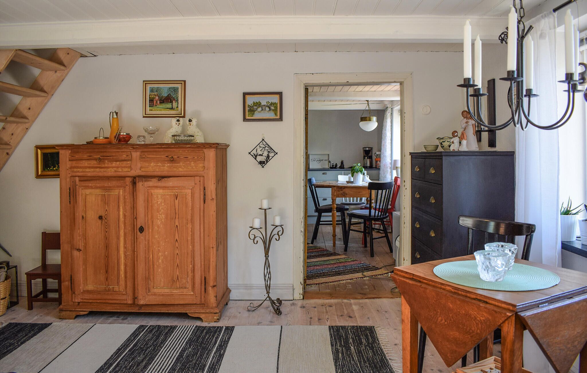 Une cuisine chaleureuse avec des meubles de rangement en bois, une table à manger et un escalier.