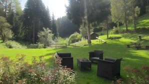 A grassy outdoor area with picnic tables and chairs, surrounded by trees and a small wooden structure. - Single Room with Shared Terrace, Balcony, and Wi-Fi (Altensteig)