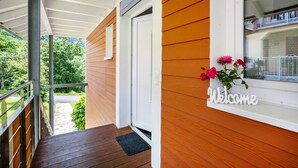 A wooden exterior with a welcome sign, a door, and a window. - Apartment 'Teufelsmühlblick' with Mountain View, Balcony and Wi-Fi (Loffenau)