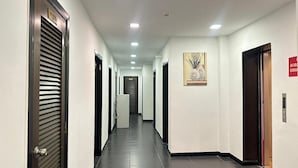 A hotel corridor with doors, a framed artwork, and a sign indicating a room type. - Homigo - PWTC (Kuala Lumpur)