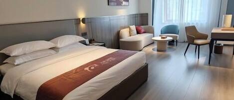 Une chambre d’hôtel moderne avec un grand lit, un canapé, un bureau et une chaise.