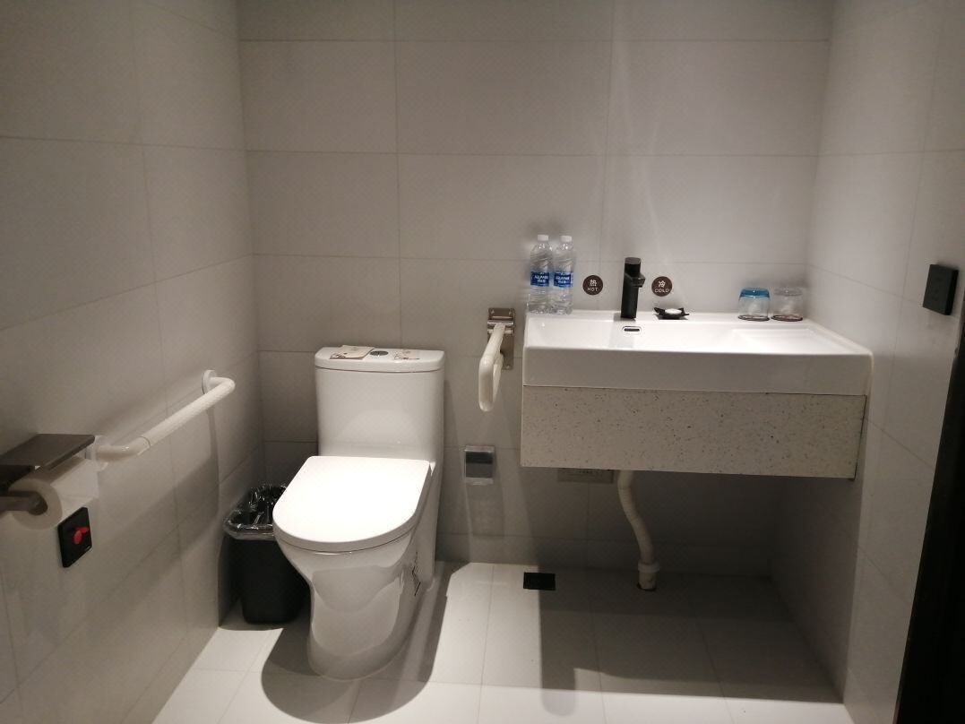 Un baño pequeño y moderno con inodoro, lavabo y secador de manos.