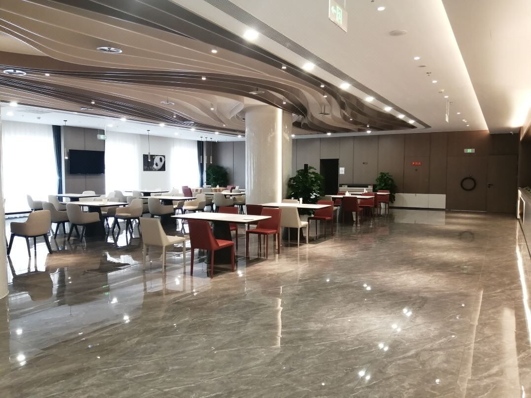 A spacious indoor area with tables and chairs arranged for dining.