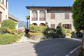 Un bâtiment à deux étages doté d’une façade en pierre, de fenêtres en arc de cercle et d’un balcon orné d’une balustrade en fer forgé.