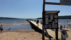 A wooden pier extending into a lake with a sign reading "Satila" at the end.