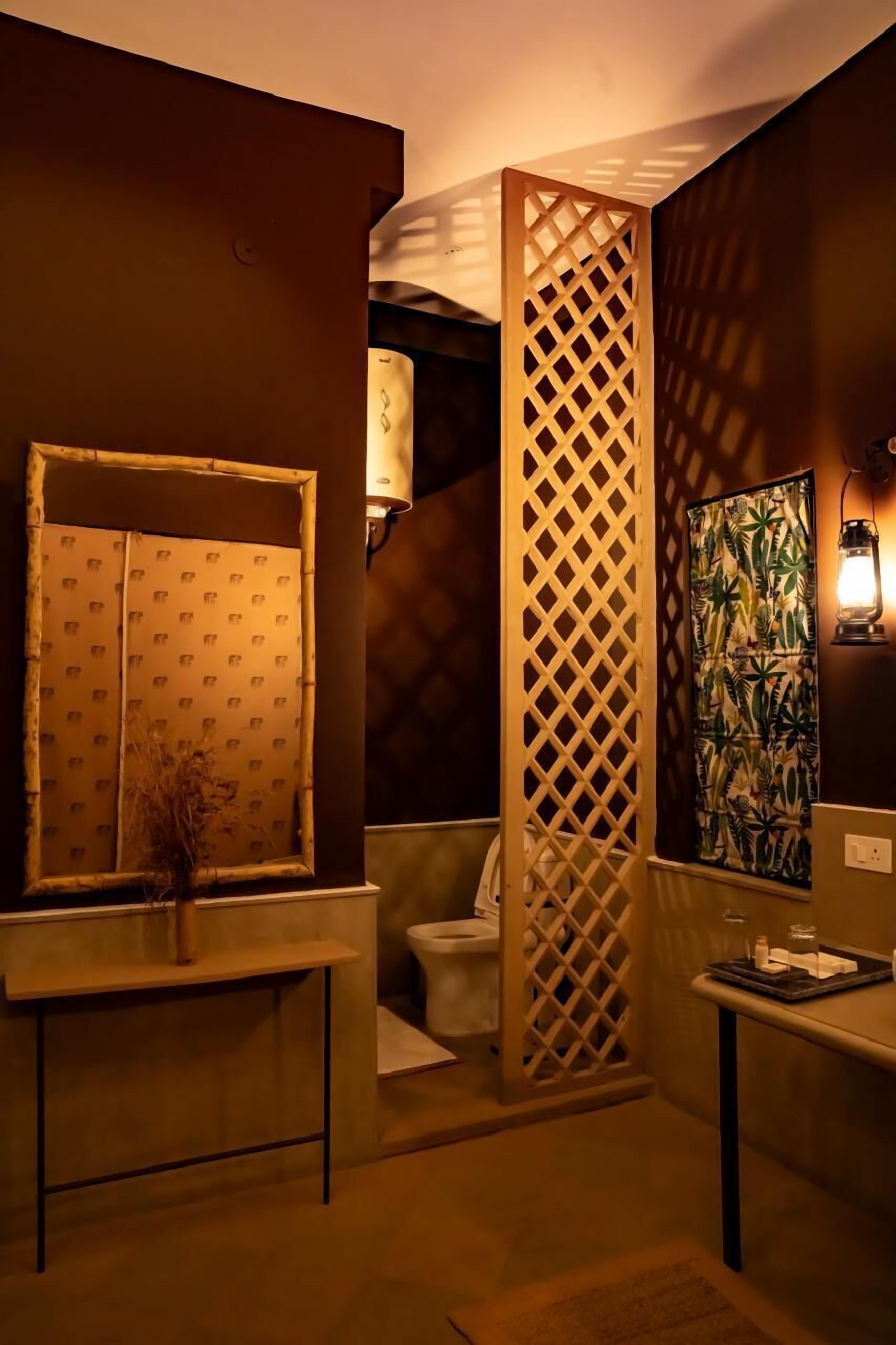 Een badkamer met een houten spijlenwand, een raam met patroon, een toilet en een klein tafeltje met dienblad.