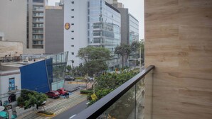 Un edificio moderno con fachada de vidrio, toldo azul y una señal peatonal amarilla.