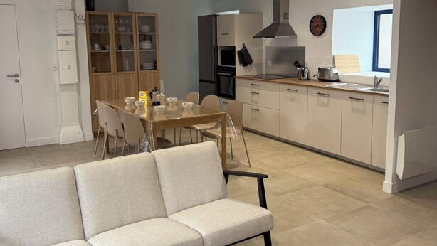 Una sala de estar moderna con un sofá, una mesa de centro y un comedor con sillas y una mesa.