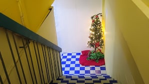 Una escalera con un piso de diseño ajedrezado que lleva a un árbol de Navidad decorado.
