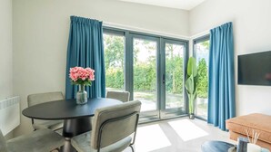 A modern room with a dining table, chairs, a sofa, and a TV. - Welcome to Muralt 110, a modern chalet with everything for a carefree stay. Enjoy the cozy living ro (Scharendijke)
