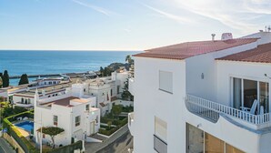 A coastal residential area with white buildings, a swimming pool, and a view of the sea. - Apartment Atlas (Albufeira)