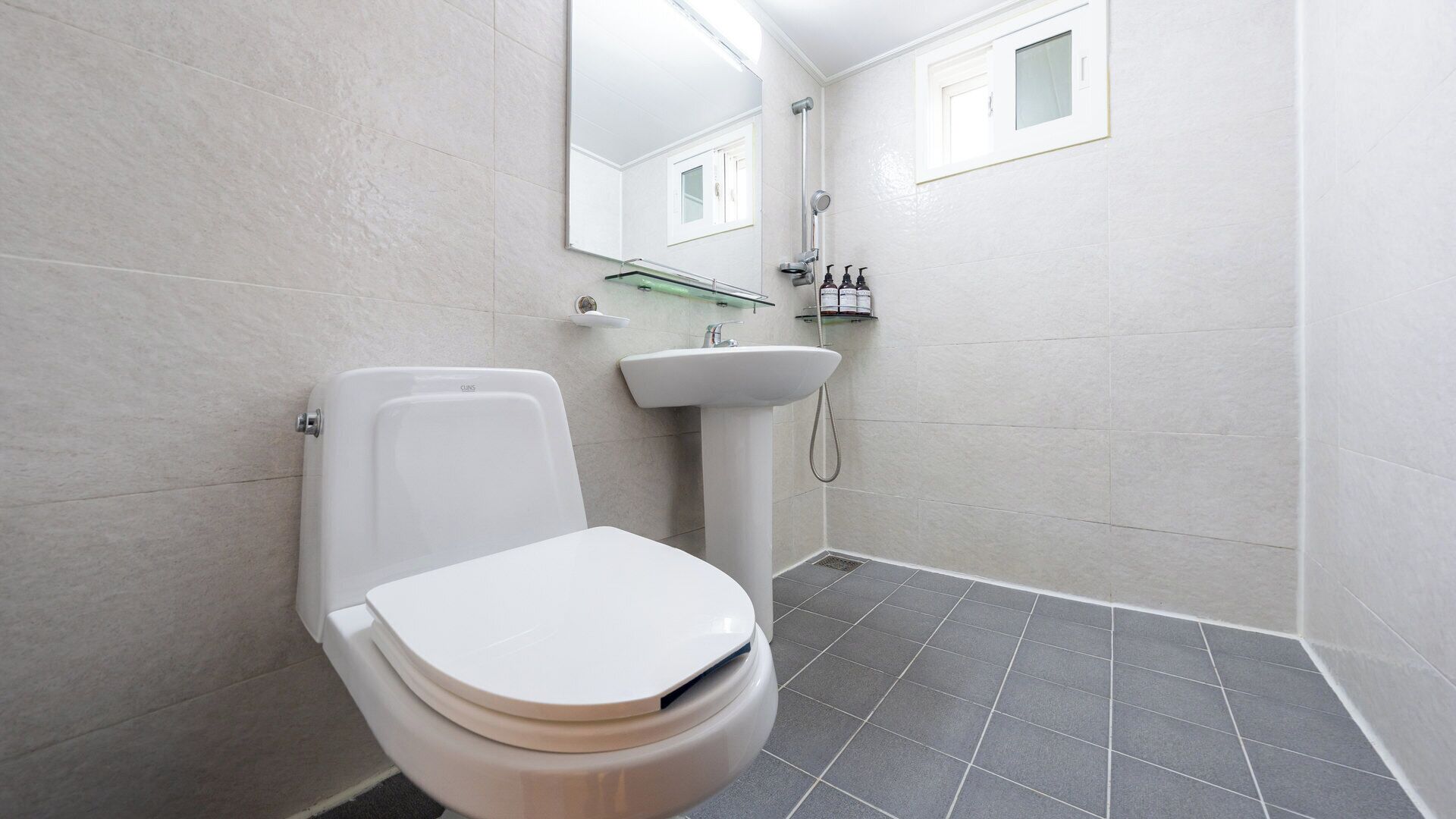 A modern bathroom with a toilet, sink, and shower.