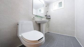A modern bathroom with a toilet, sink, and shower.