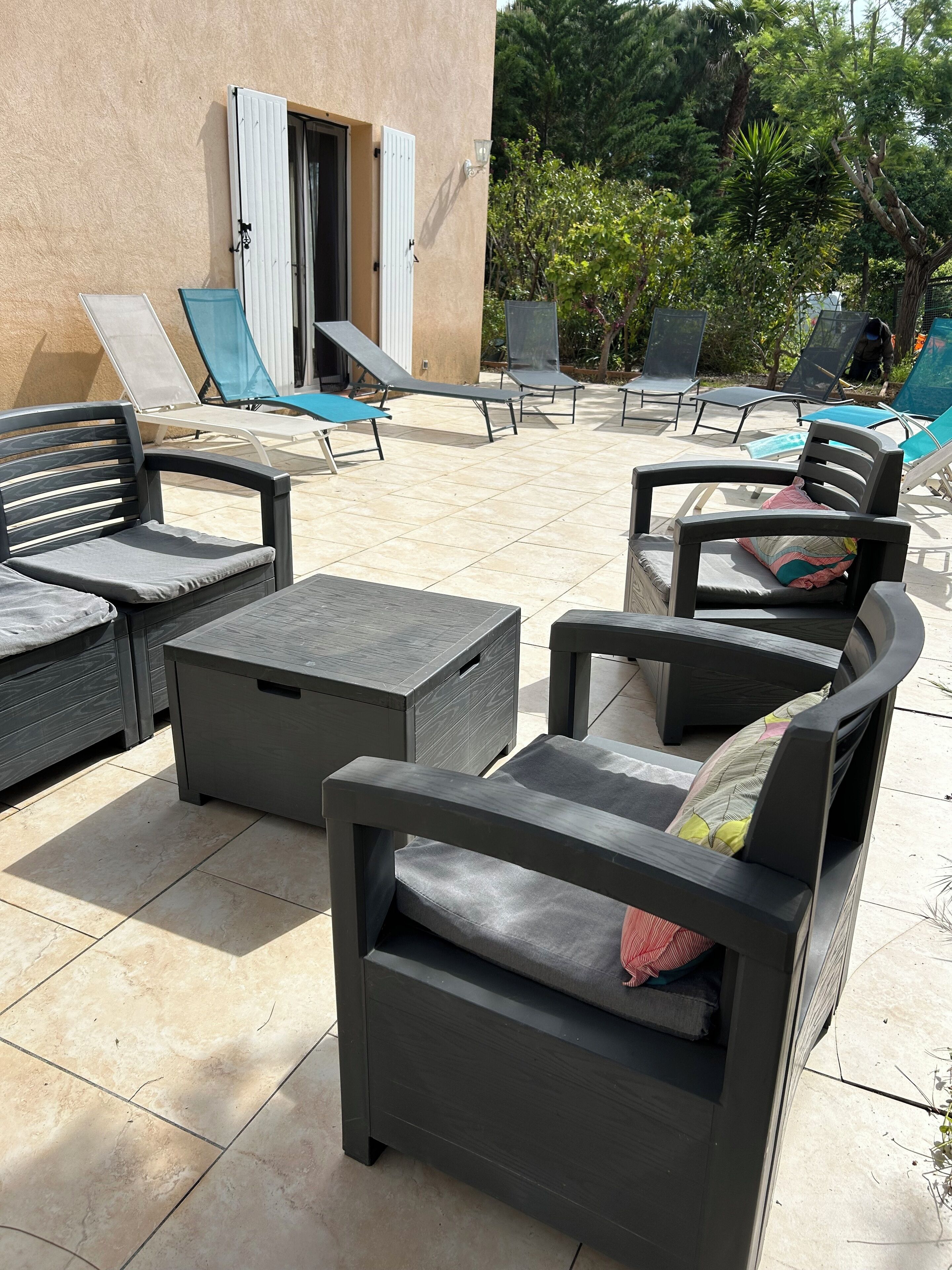 An outdoor patio with lounge chairs and a dining area.