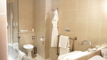 Un baño moderno con ducha de vidrio, inodoro blanco, bañera y lavamanos.