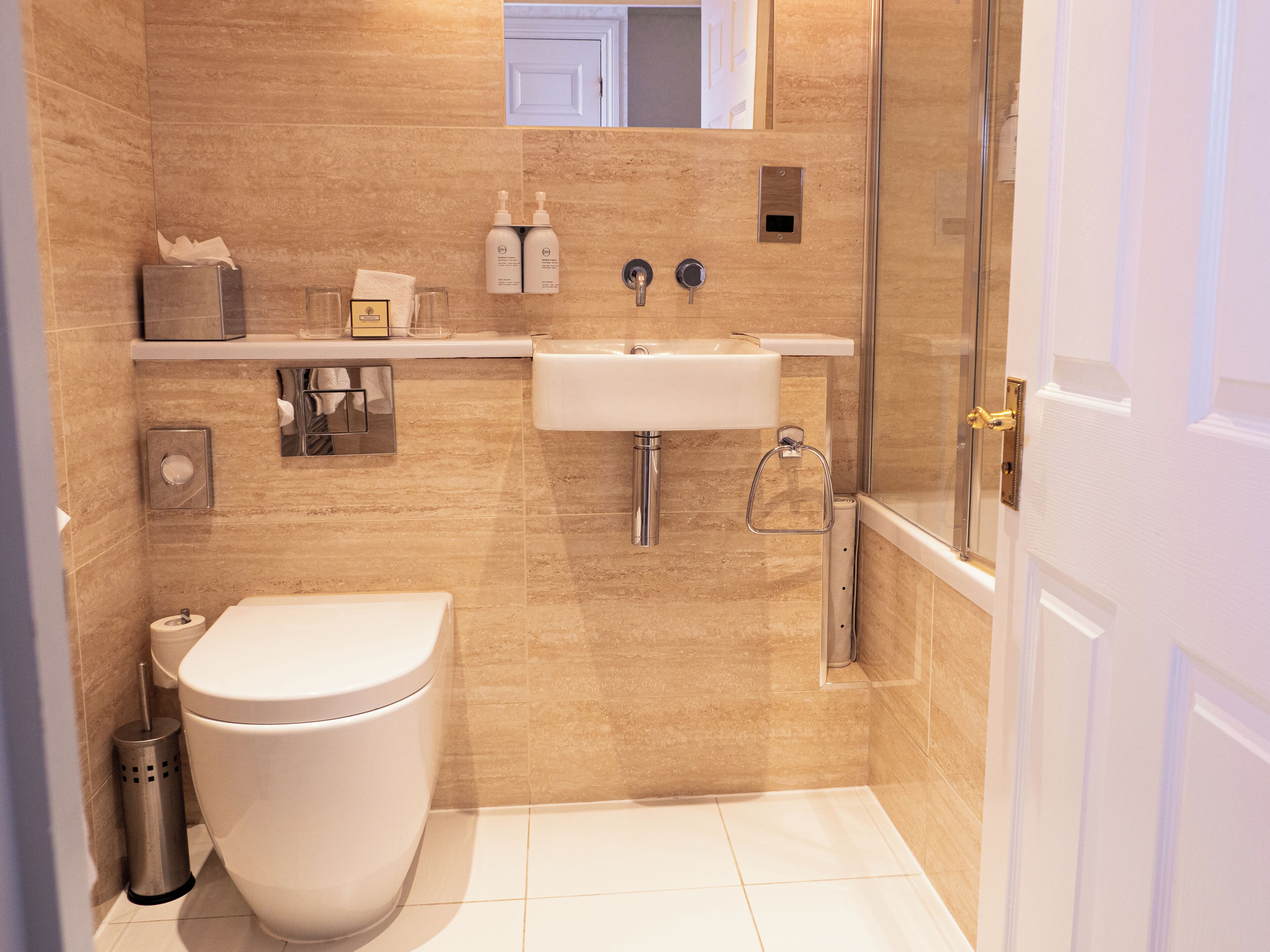 A modern bathroom with a toilet, sink, and shower.