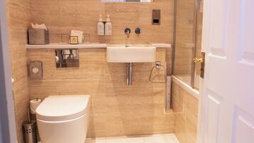 A modern bathroom with a toilet, sink, and shower.