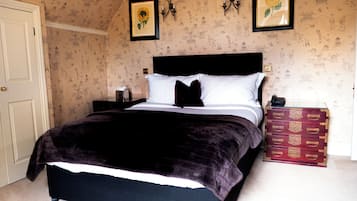 Ein Schlafzimmer mit Bett, Nachttisch, Kommode und einer Tür.