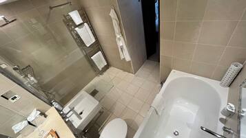 Ein modernes Badezimmer mit Badewanne, Toilette, Waschbecken und Duschbereich.
