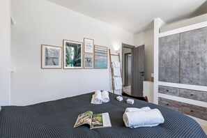Ein ordentlich eingerichtetes Schlafzimmer mit einem großen Bett, einem Holzschrank und gerahmten Bildern an der Wand.