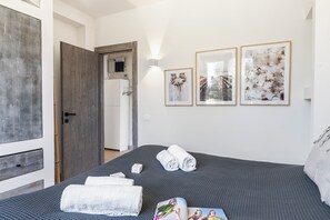 A bedroom with a bed, towels, and framed artwork on the wall. - Villa Tartaruga Luxury With Pool (Carovigno)