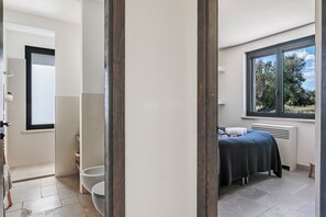 A modern bathroom with a toilet, sink, and a large window.