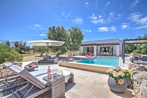 A modern outdoor pool area with lounge chairs, a dining area, and a pergola. - Villa Tartaruga Luxury With Pool (Carovigno)