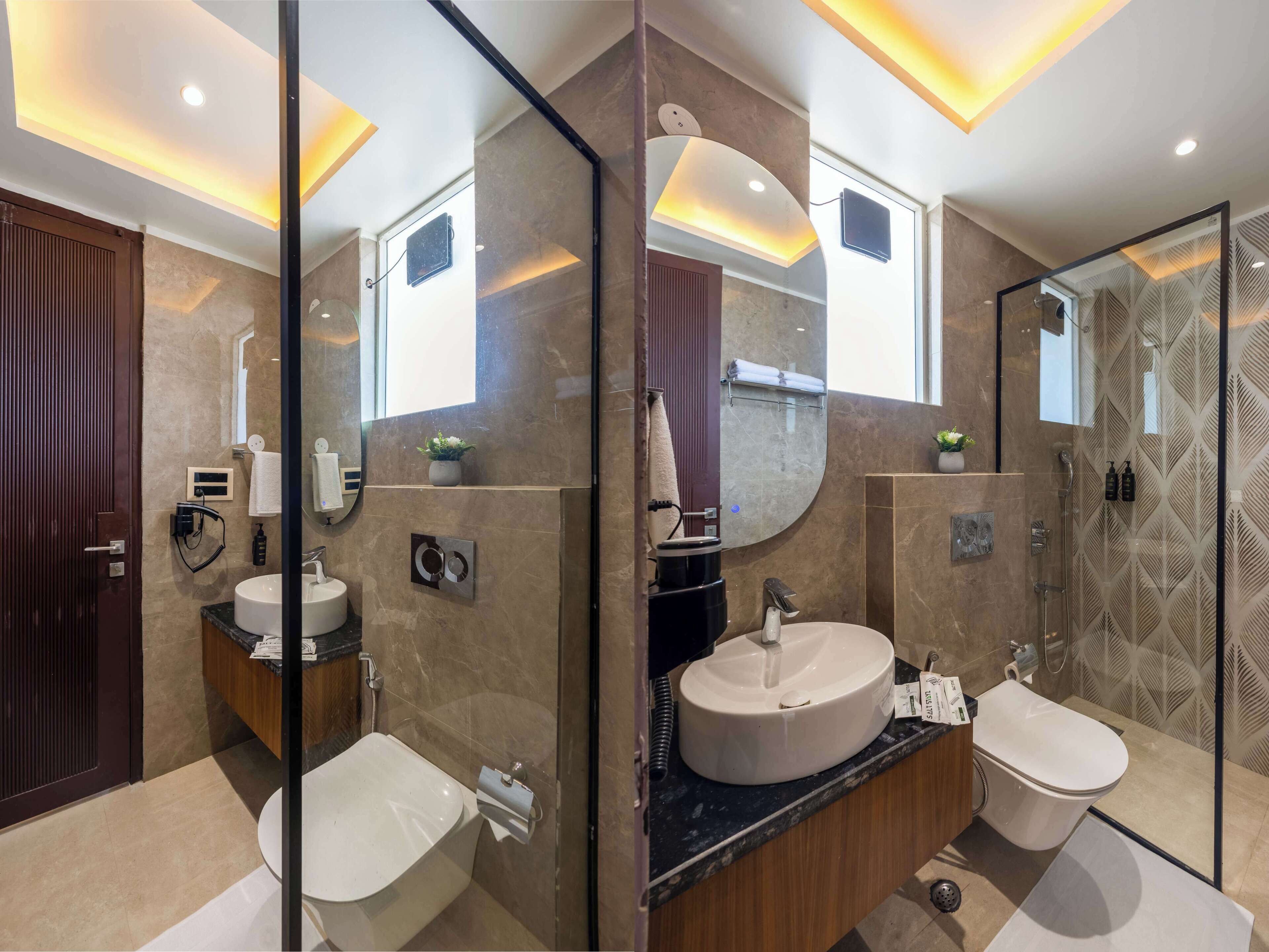 A modern bathroom with a glass partition, a round sink, a toilet, and a shower area.