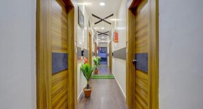 Un passadís amb portes de fusta, ventiladors de sostre i plantes en testos.