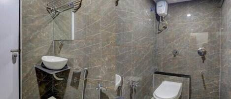Un baño moderno con pared de mármol, lavabo, inodoro y ducha.