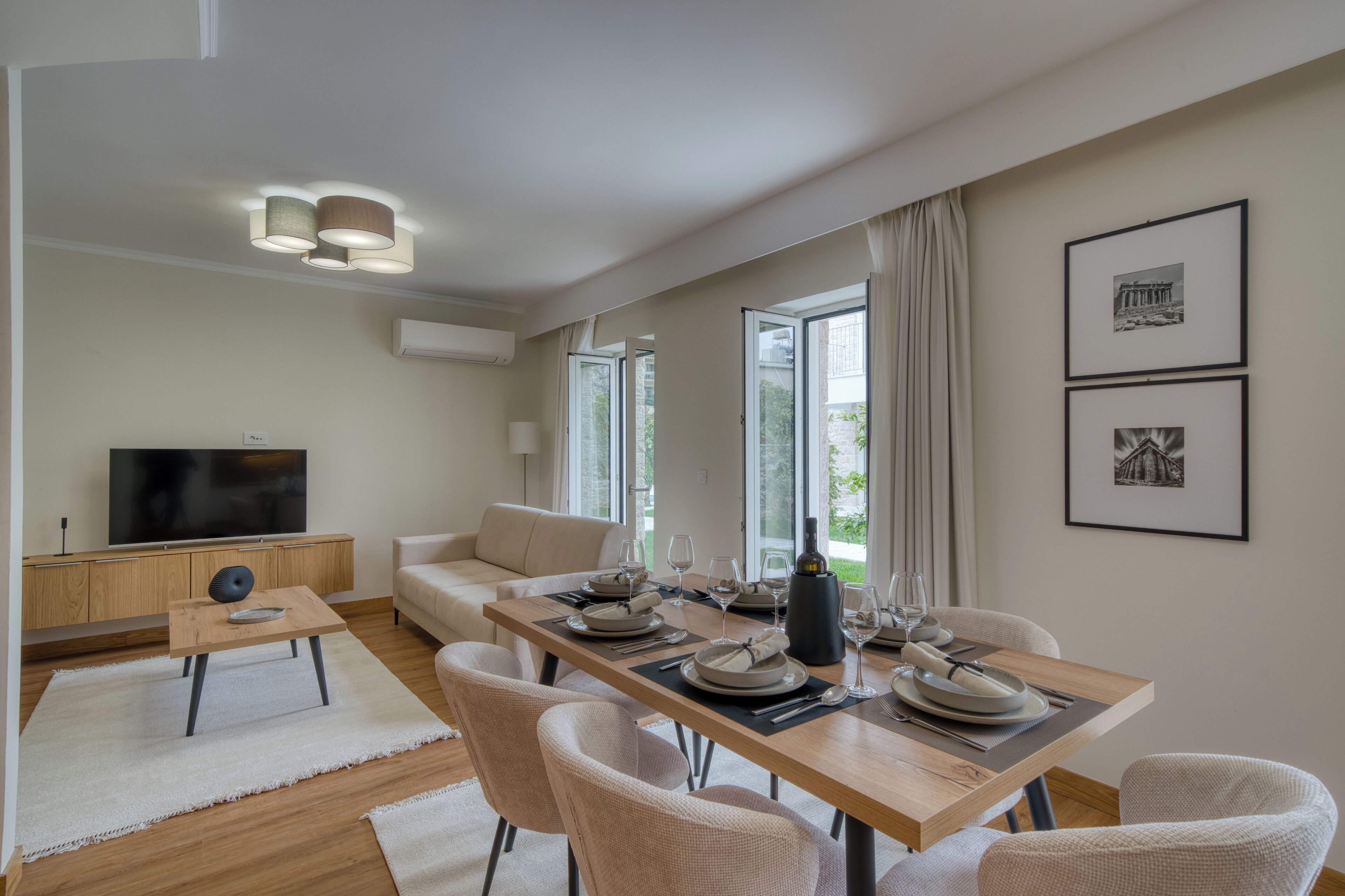 Una sala de estar moderna con comedor, televisor de pantalla plana y sofá.
