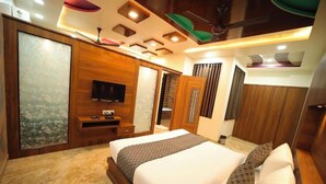 Een moderne slaapkamer met een groot bed, een houten garderobe en een televisie.