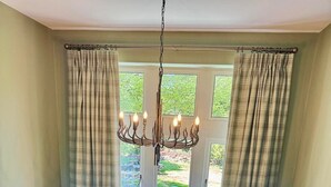 A room with a view through a window, a chandelier, and a wooden staircase. - Redstones Hotel (Appleby-in-Westmorland)