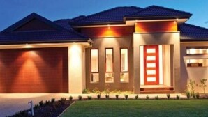 Een modern huis met twee verdiepingen, een verzorgd gazon, een garage en een oprit.