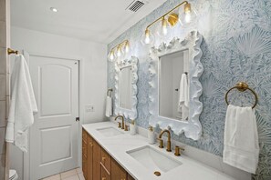 A bathroom with two sinks, a mirror, and a towel rack. - Steps 2 Beach | Pool/SPA | Game Room | Pool Table (Palm Beach Shores)